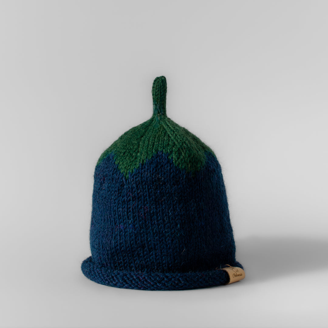 Lasten sininen neulottu käsintehty mustikka pipo, jossa vihreä lehtiosa ja vihreä retro antenni.