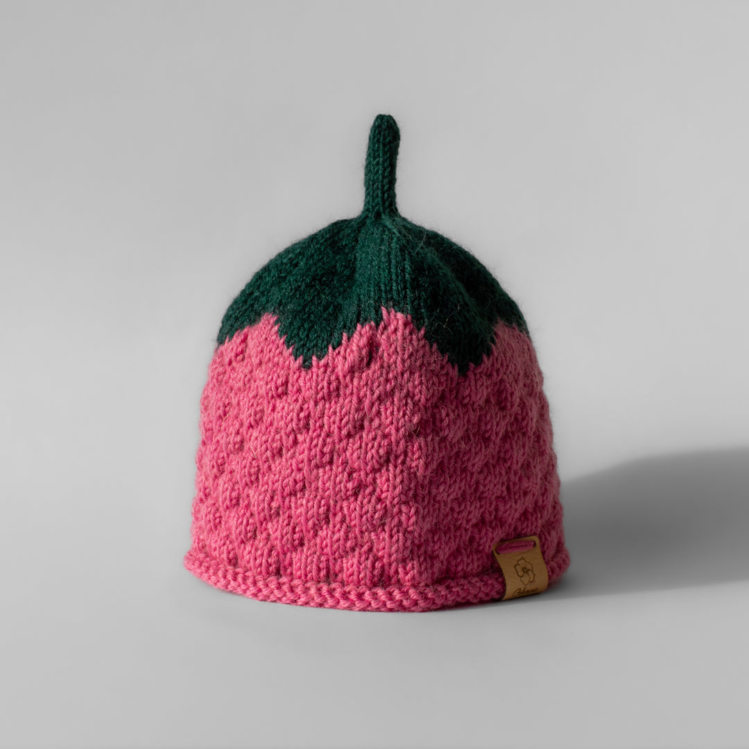 Lasten vaaleanpunainen tai pinkki neulottu käsintehty vadelma pipo, jossa kupla kuviota sekä vihreässä lehtiosassa antennivarsi.